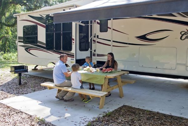 Family at picnic table outside of RV camper