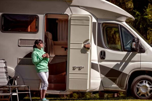 Lady standing outside RV with coffee